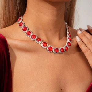 Close-up of sparkling diamond-encrusted red ruby necklace on female model neck