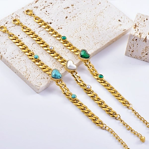 Detail of gold curb chains with heart and round turquoise and pearl charms