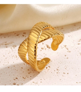 Macro shot of gold crisscross textured ring with vertical ridges on beige stand