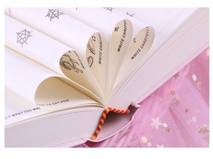 Macro view of the answer book with fanned pages and decorative star tulle background