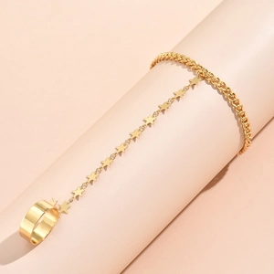 Detail of gold star charm finger bracelet chain and wide band ring set for women