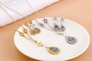 Detailed view of leaf jewelry set with zircons and Forever Love engraving
