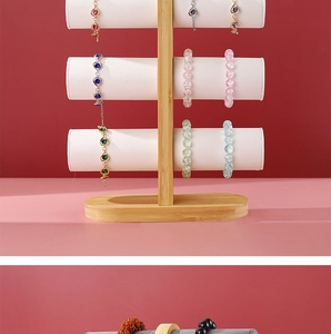 Detailed view of 3-tier bamboo jewelry stand with white cylinders for bracelets and watches