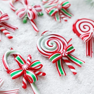 Christmas candy cane and lollipop ornaments in red white and green on artificial snow