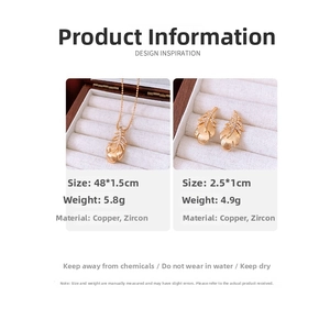 Detail of 18k gold plated feather pendant and earrings set with micro-pave cubic zirconia