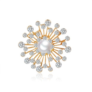 Detailed view of stethoscope brooch with white pearl, gold metal rays and crystals