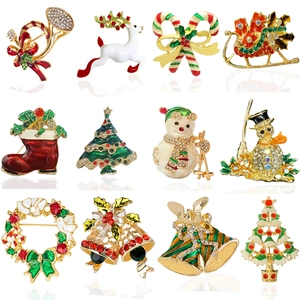 Detailed grid of twelve gold Christmas brooches featuring reindeer, trees, and bells