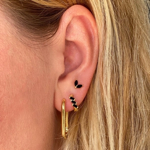 Close-up of s925 silver needle hoop earrings with black rectangular zircons and gold finish