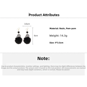 Detailed view of resin striped earrings with black pom-poms and gold hooks, 9x3.5cm