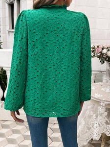 Detail view of the back of a green embroidered top with hollow lace and puff sleeves