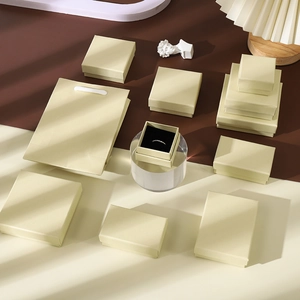 Detail of Gobi yellow jewelry boxes and paper bag with a ring in black foam insert