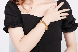 Close-up of golden double-layer titanium sun pendant bracelet worn by a model
