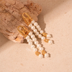Details von Vintage zwelagigen Perlenohrringen mit goldenen Elementen und Steinteilen