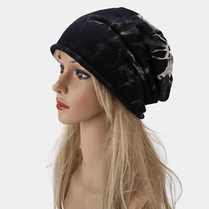 Detailed side view of black and white tie-dye knit slouchy beanie on a model head