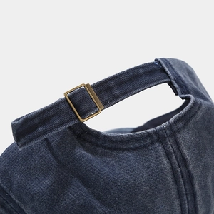 Close-up of vintage washed denim baseball cap with adjustable bronze metal buckle