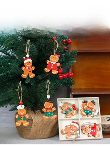 Detail of wooden gingerbread man ornaments hanging on a Christmas tree in a gift box set