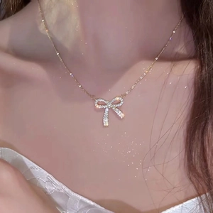Close-up of elegant bow pendant necklace with zircons worn on a model's neck