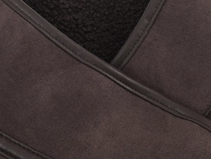 Macro detail of high-quality brown suede fabric with thick black faux fur lining and stitching