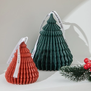 Christmas tree scented candles in red and green with festive pine branch decor