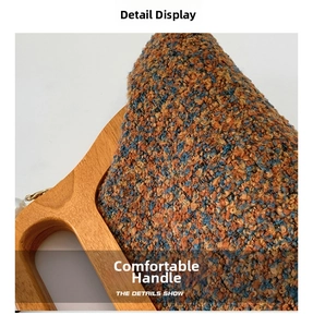 Detail of tweed evening bag featuring mixed orange fabric and polished wooden handle