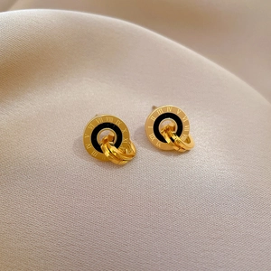 Macro detail of gold-plated roman numeral studs on elegant beige silk background