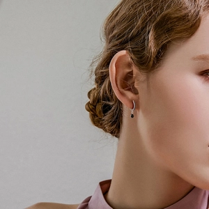 Close-up of S925 silver hoop earrings with black zircon and drop-shaped gemstone pendant