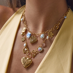 Détails d'un collier doré multicouche avec perles en céramique florales et cœurs