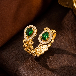 Macro detail of adjustable gold ring with double green teardrop zircon stones