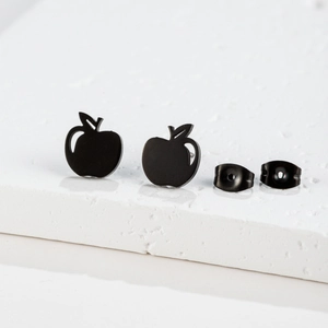 Detailed close-up of matte black stainless steel apple-shaped stud earrings on white pedestal