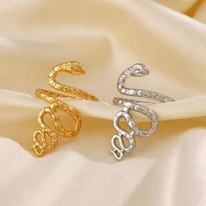 French vintage snake rings in gold and silver steel on elegant silk fabric background