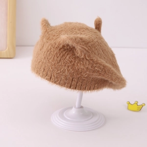 Détail du béret en peluche marron avec oreilles de chat mignonnes et texture tricotée