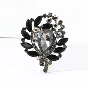 Detailed close-up of retro gold floral brooch featuring black and grey crystals