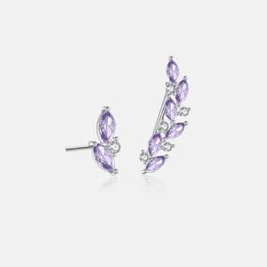 Macro shot of asymmetric silver earrings with purple marquise gemstones and white zircons