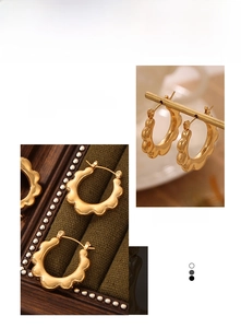 Macro detail of gold plated sunflower hoop earrings with a wavy edge on velvet
