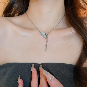 Close-up of butterfly pendant necklace with silver tassels and sparkling rhinestone accents