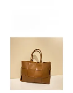 Detailed close-up showing the premium Intrecciato woven leather texture of the tote bag