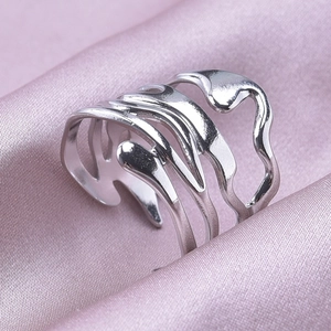 Detailed view of silver liquid metal style ring on light purple silk fabric background