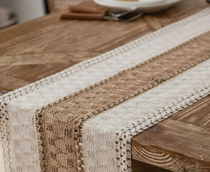 Close-up of bohemian woven table runner with beige and brown cotton linen stitching