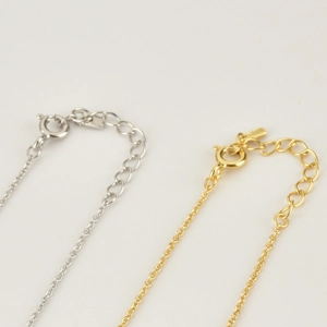 Close-up of gold and silver sterling silver cross bracelets with spring clasp and chain