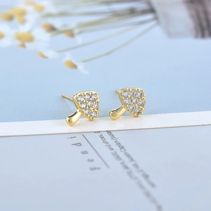 Macro detail of S925 silver mushroom earrings with colorful crystals on a magazine