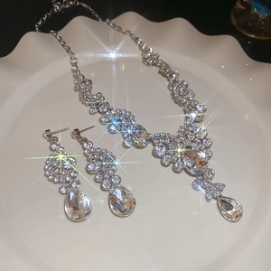 Elegant diamond fan-shaped water drop necklace and earrings set on a white tray