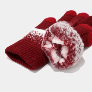 Detail of burgundy knit gloves with Nordic snowflake pattern and thick fleece lining
