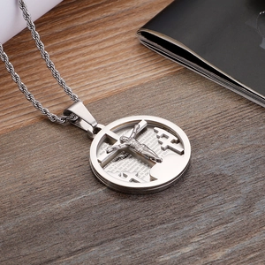 Macro shot of silver stainless steel cross pendant with engraved Spanish prayer scripture