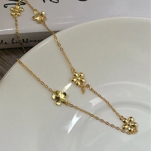 Detailed view of the gold 925 sterling silver chain featuring delicate daisy floral charms