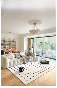 Detail of minimalist cream carpet with black squares in a modern living room setting