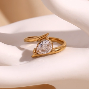 Macro view of 18K gold plated wing-shaped ring with a pear-cut white zircon on a hand model