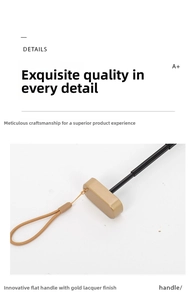 Detailed view of the innovative flat umbrella handle with gold-painted finish and wrist strap