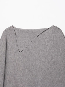 Gros plan du col asymétrique plié sur un haut en maille texturée grise pour femmes