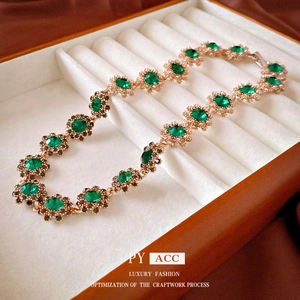 Bracciale vintage dorato con cristalli verdi e chiusura floreale in scatola di lusso