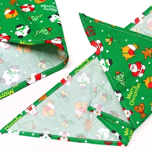 Green Christmas dog bandana featuring holiday prints like Santa and gingerbread men